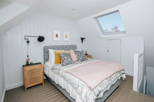 a bedroom with a bed with pillows and a window at The Neptune in Henley on Thames