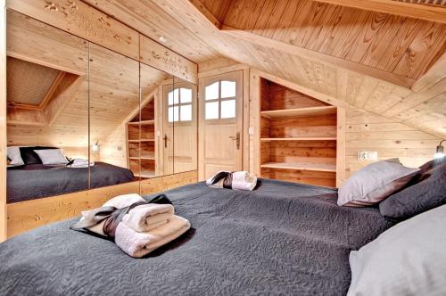 a room with two beds in a wooden cabin at Apartamenty Światłomir in Zakopane