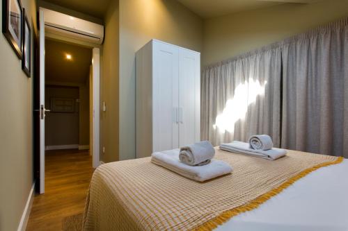 a bedroom with a bed with towels on it at RVA - Porto Central Flats in Porto