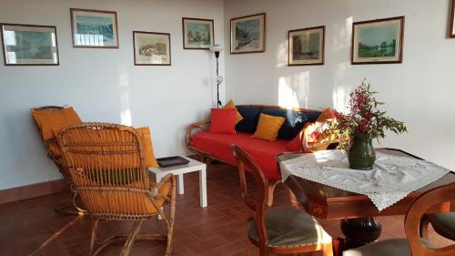 a living room with a red couch and a table at Casa con piscina camino e biliardo in San Giustino Valdarno