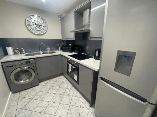 a kitchen with a sink and a washing machine at Hosted By Ryan - Studio Apartment in Liverpool