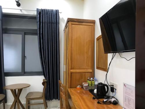 um quarto com uma televisão e uma mesa com mesa em ĐỨC THẠNH HOTEL em Rạch Giá