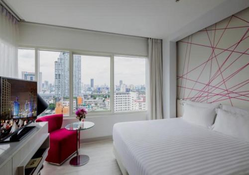 a hotel room with a bed and a large window at Centara Watergate Pavilion Hotel Bangkok in Bangkok