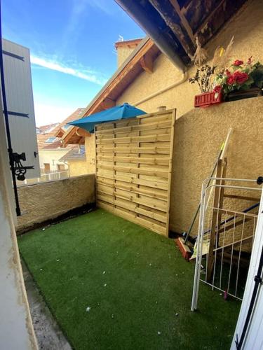 une cour avec une clôture en bois et de l'herbe verte dans l'établissement Gap - Joli studio en plein centre-ville, à Gap
