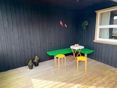 a green table and two stools in a room at Nice one-story house in Suduroy in Tvøroyri