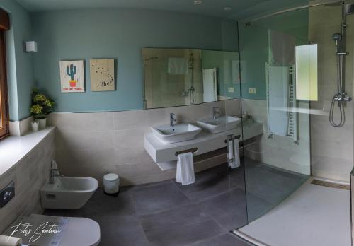 a bathroom with two sinks and a shower at Apartamentos Buenavista Tineo in Tineo