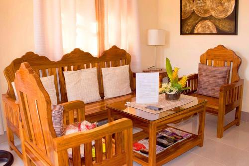a living room with wooden chairs and a table at Haisa Apartment in Coron