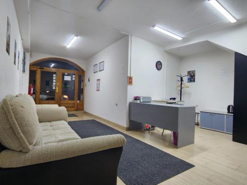 ein Wohnzimmer mit einem Sofa und einem Schreibtisch in der Unterkunft Hostel Center in Sarajevo