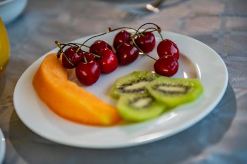 a white plate with fruit on a table at Aparthotel Isabella in Sciacca