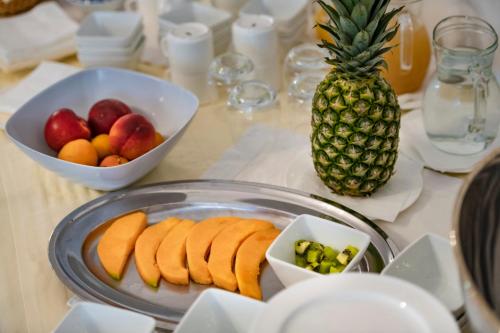 a table with a plate of fruit and a pineapple at Aparthotel Isabella in Sciacca