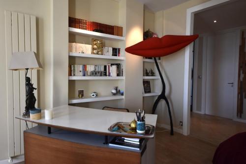 un salon avec un bureau avec une lampe rouge dans l'établissement MV Gallery Collection, Beau Bourgeois vue Mer, à Cannes