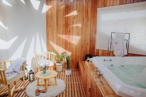 a bathroom with a tub and a table and chairs at Hostería El Coirón in Esquel