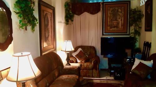 sala de estar con sofá y lámpara en The Savannah is at your doorstep! en Puerto España