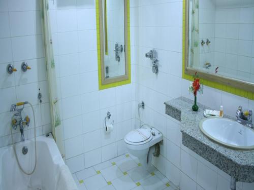 a bathroom with a toilet and a sink and a tub at Shingar Regency in Manāli