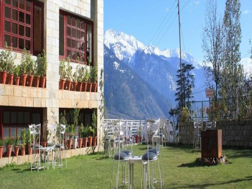 a group of chairs and tables in front of a building at Shingar Regency in Manāli