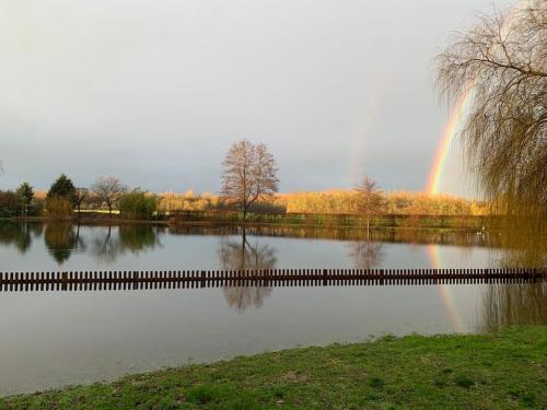 a rainbow over a pond with a rainbow at L’Eden de JoLéo : votre cocon d’amour in Perthes