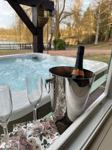 - une bouteille de champagne dans un seau près de la piscine dans l'établissement L’Eden de JoLéo : votre cocon d’amour, à Perthes