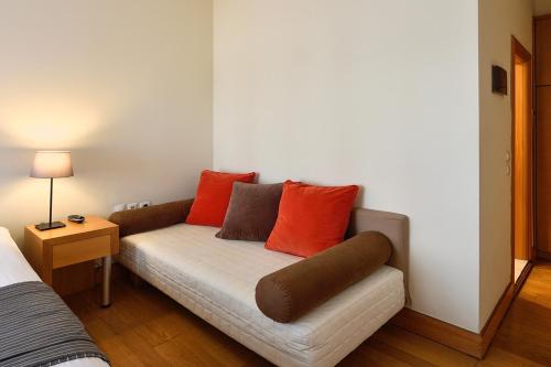 a couch with orange pillows on it in a room at Le Palace Hotel in Thessaloniki