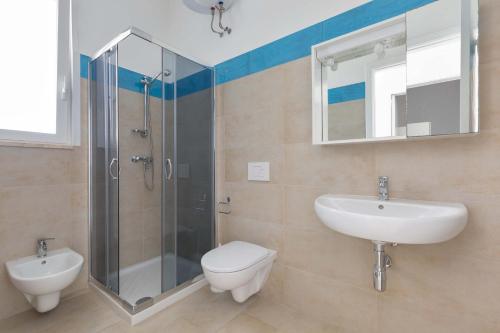 e bagno con servizi igienici, lavandino e doccia. di Residence Mare Azzurro by BarbarHouse a Porto Cesareo