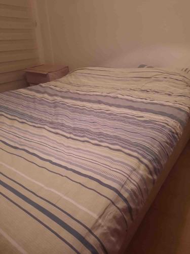 ein Bett mit einer gestreiften Decke darüber in der Unterkunft Private Room in Istanbul #109 in Istanbul