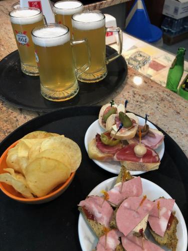 a table with two plates of sandwiches and glasses of beer at Albergo Sala in Valbrona