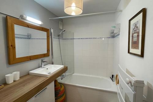 een badkamer met een wastafel en een bad bij Appartement MerliDunes Proche de la plage in Merlimont