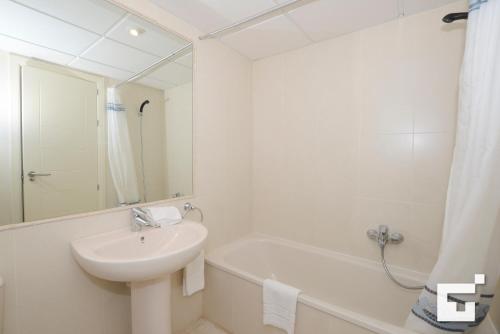 a white bathroom with a sink and a bath tub at Apartamento Amatista 29A - Grupo Turis in Calpe