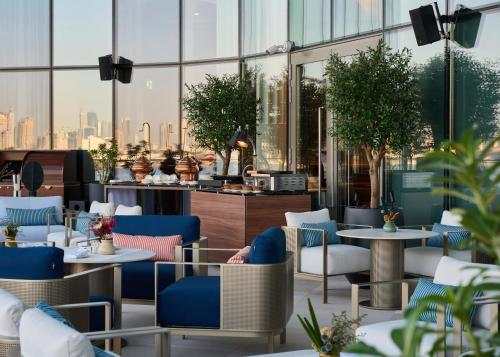 uitzicht op een restaurant met tafels en stoelen bij Address Grand Creek Harbour in Dubai