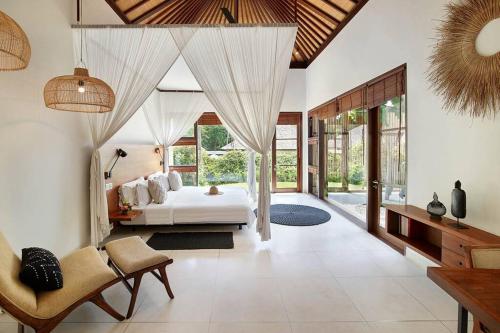 a bedroom with a white bed in a room at Villa Bengawan in Canggu