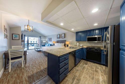 een keuken met blauwe kasten en een bed in een kamer bij Park Plaza Resort Park City, a Ramada by Wyndham in Park City
