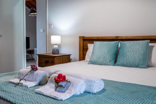 a bedroom with a bed with towels and flowers on it at Oásis Fonte Grande in Santo António