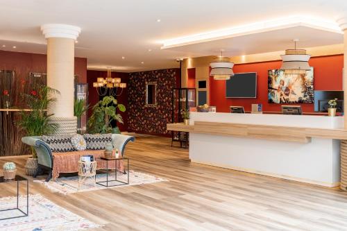 a lobby of a hotel with red walls and a bar at Aiden by Best Western Paris Roissy CDG in Roissy-en-France