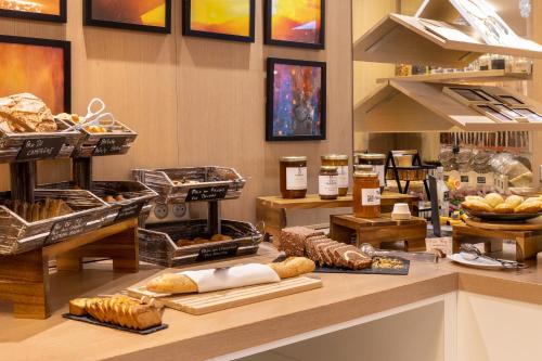 a bakery with bread and pastries on a counter at Aiden by Best Western Paris Roissy CDG in Roissy-en-France