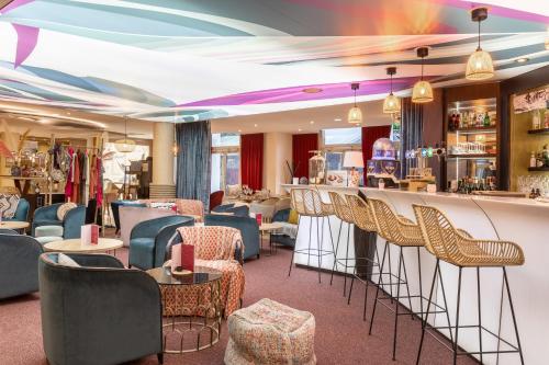 a bar in a restaurant with chairs and a counter at Aiden by Best Western Paris Roissy CDG in Roissy-en-France