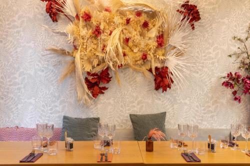 a table with glasses and a flower chandelier on a wall at Aiden by Best Western Paris Roissy CDG in Roissy-en-France