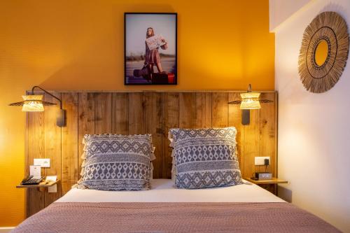 a bedroom with a bed with blue and white pillows at Aiden by Best Western Paris Roissy CDG in Roissy-en-France