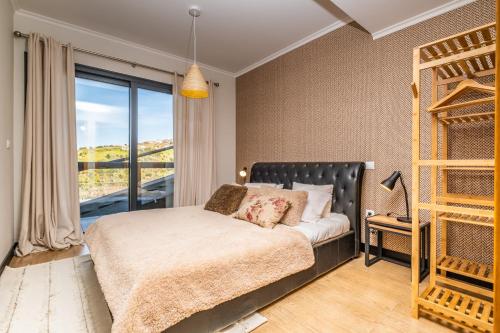 a bedroom with a bed and a large window at Ocean Panorama Apartments by Madeira Sun Travel in Calheta