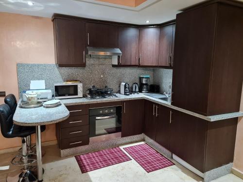 a kitchen with wooden cabinets and a counter top at Luxury apartment in the heart of Gueliz , Wifi, Pool in Marrakech