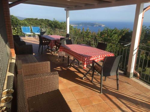 eine Terrasse mit 2 Tischen und Stühlen und Meerblick in der Unterkunft Monolocale Mimosa in Pisciotta