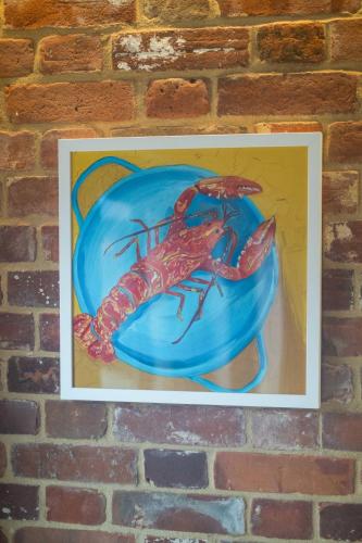 a painting of a lobster on a blue plate at Alde Bay Farm - Oyster Catcher in Aldeburgh