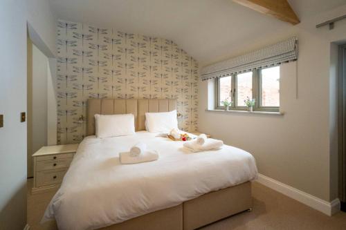 a bedroom with a bed with two towels on it at Alde Bay Farm - Oyster Catcher in Aldeburgh