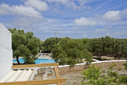 a view of a swimming pool with a bench and trees at Turismo Rural Biniati des Pi in Sant Lluis