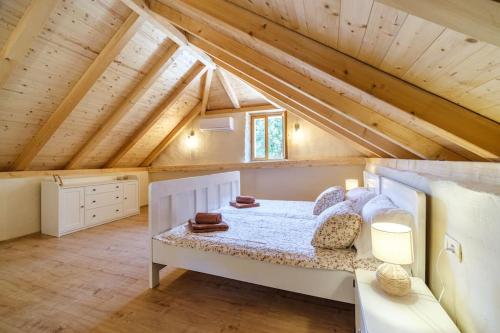 a bedroom with a white bed in a attic at Stone bridge cottage in Dol