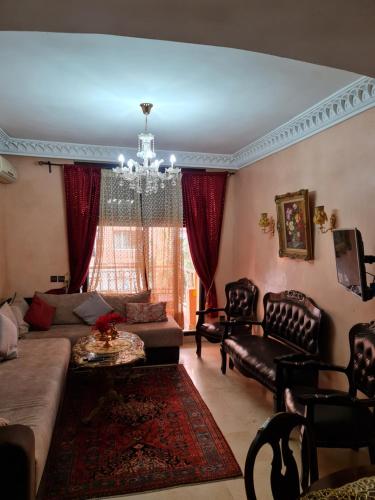 a living room with a couch and chairs and a chandelier at Luxury apartment in the heart of Gueliz , Wifi, Pool in Marrakech