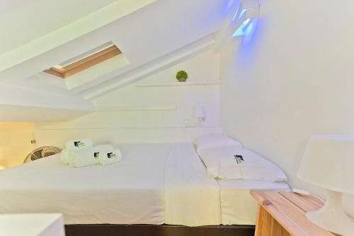 a white room with a bed with two towels at BmyGuest - Fado Mezzanine Apartment in Lisbon