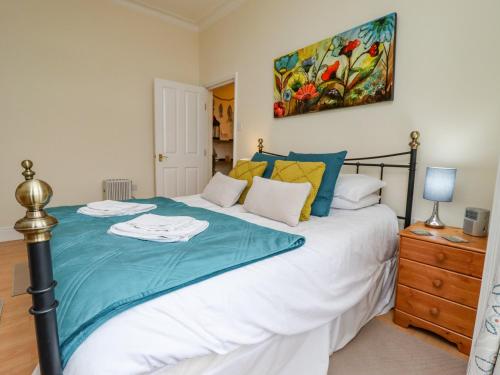 a bedroom with a bed and a painting on the wall at White Horses in Whitby