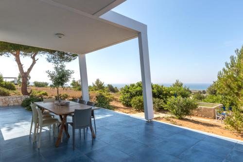 マリーナ・ディ・ペスコルーゼにあるDeluxe Pescoluse Holiday Homesの海の景色を望むパティオ(テーブル、椅子付)