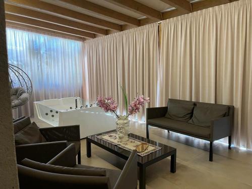 ein Wohnzimmer mit 2 Stühlen, einem Tisch und einer Badewanne in der Unterkunft Giafra Luxury Rooms in Agrigento