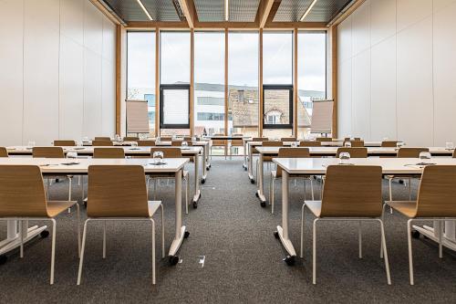 an empty classroom with rows of tables and chairs at Afterwork Hotel in Etoy