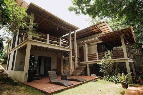 a house with a deck with two chairs on it at Playa Norte in Sabang